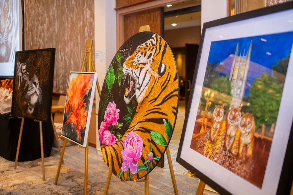 Tiger-themed artwork displayed on easels at the gala